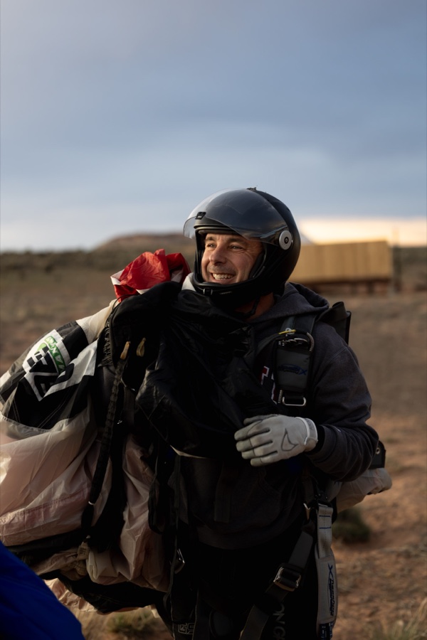 A jumper walking in with gear over the shoulder after landing