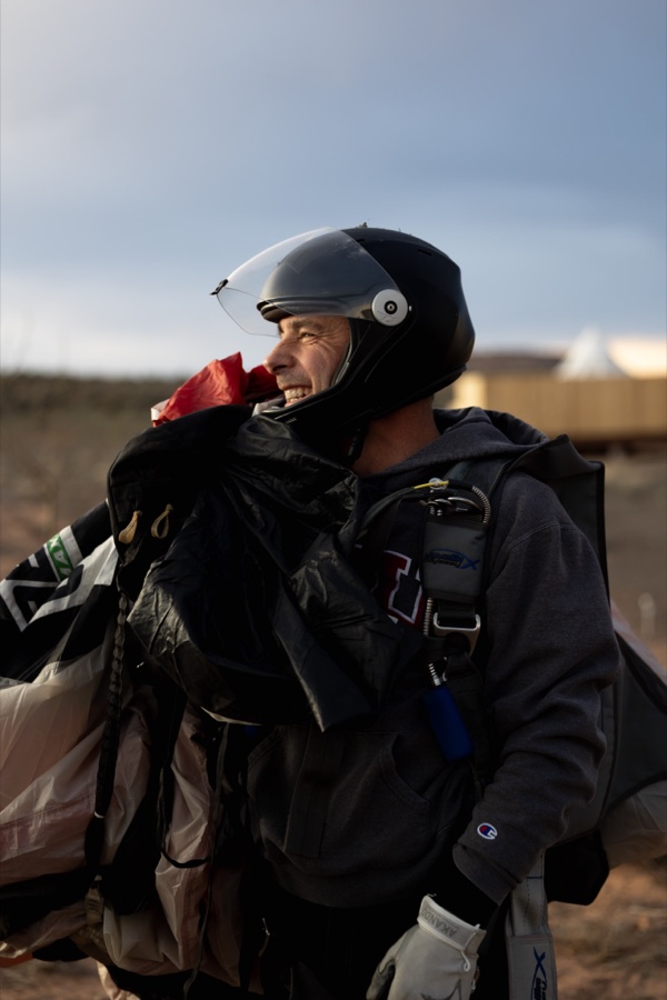 A jumper smiling under a helmet, rig over the shoulder
