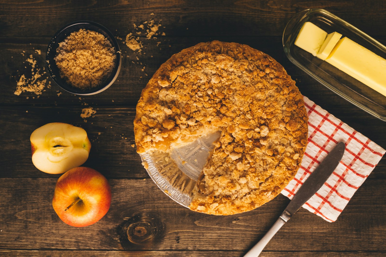 Apple crumble on a wooden table with fresh apples