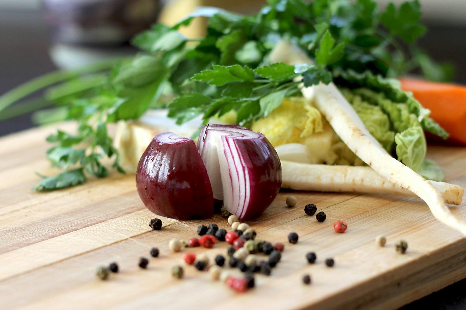 Red onion and fresh greens on a wooden cutting board