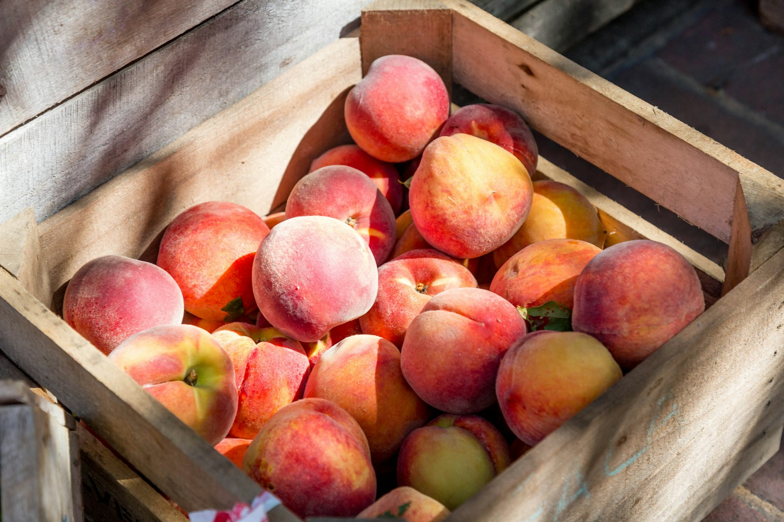 Wooden crate of ripe peaches