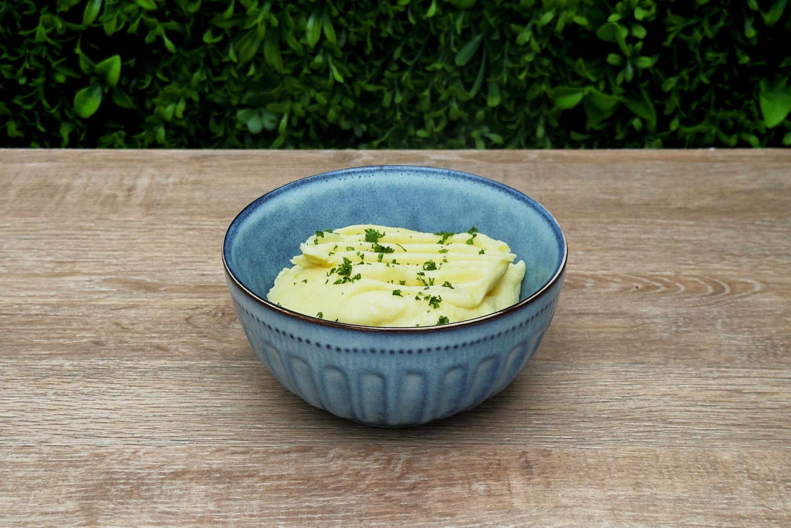 Bowl of mashed potatoes on a wooden table