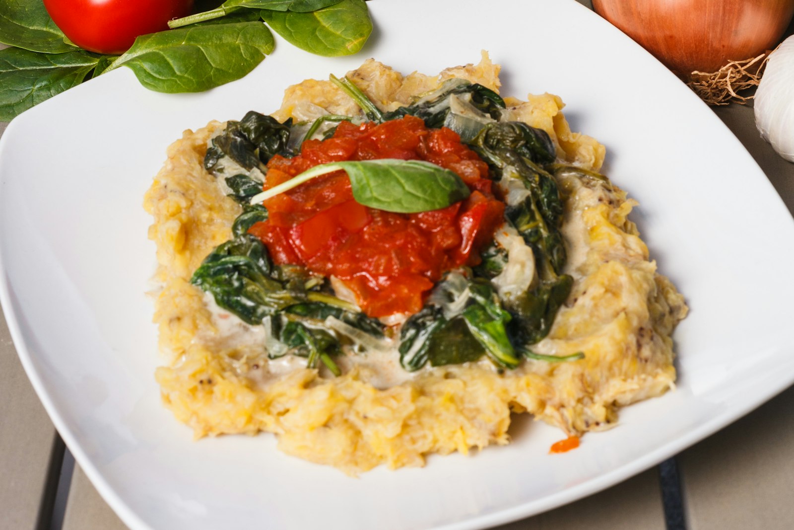 Creamy polenta with greens and tomato sauce