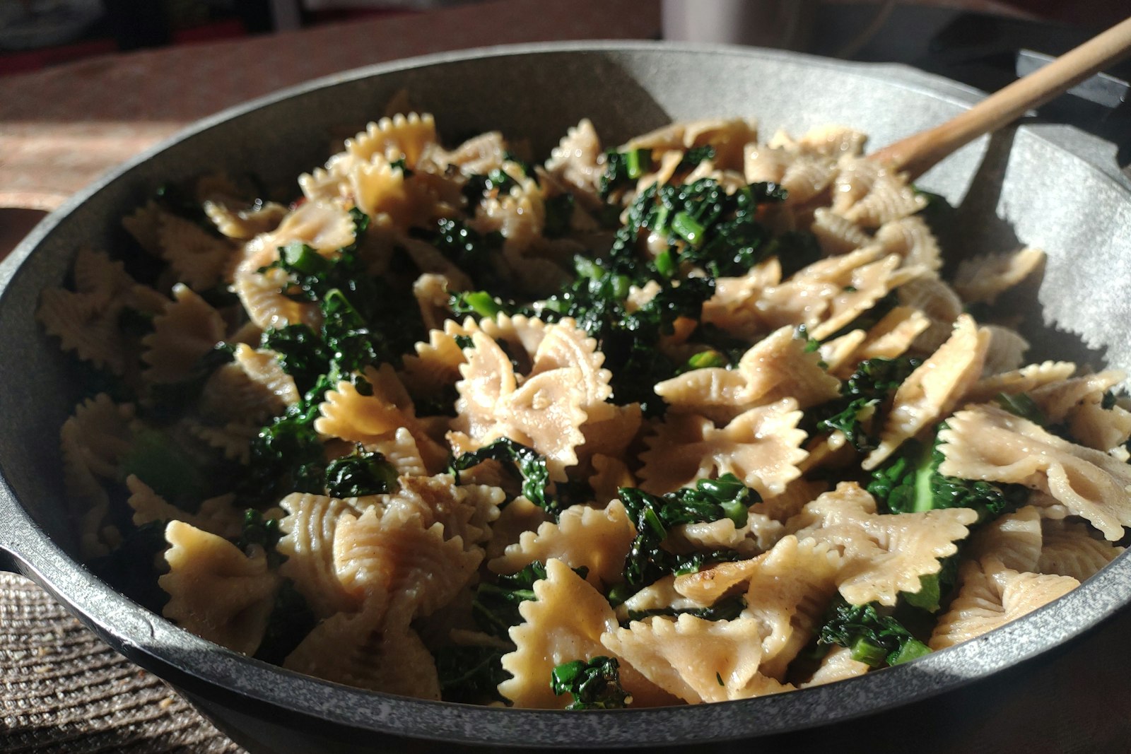 Pasta tossed with greens in a pan