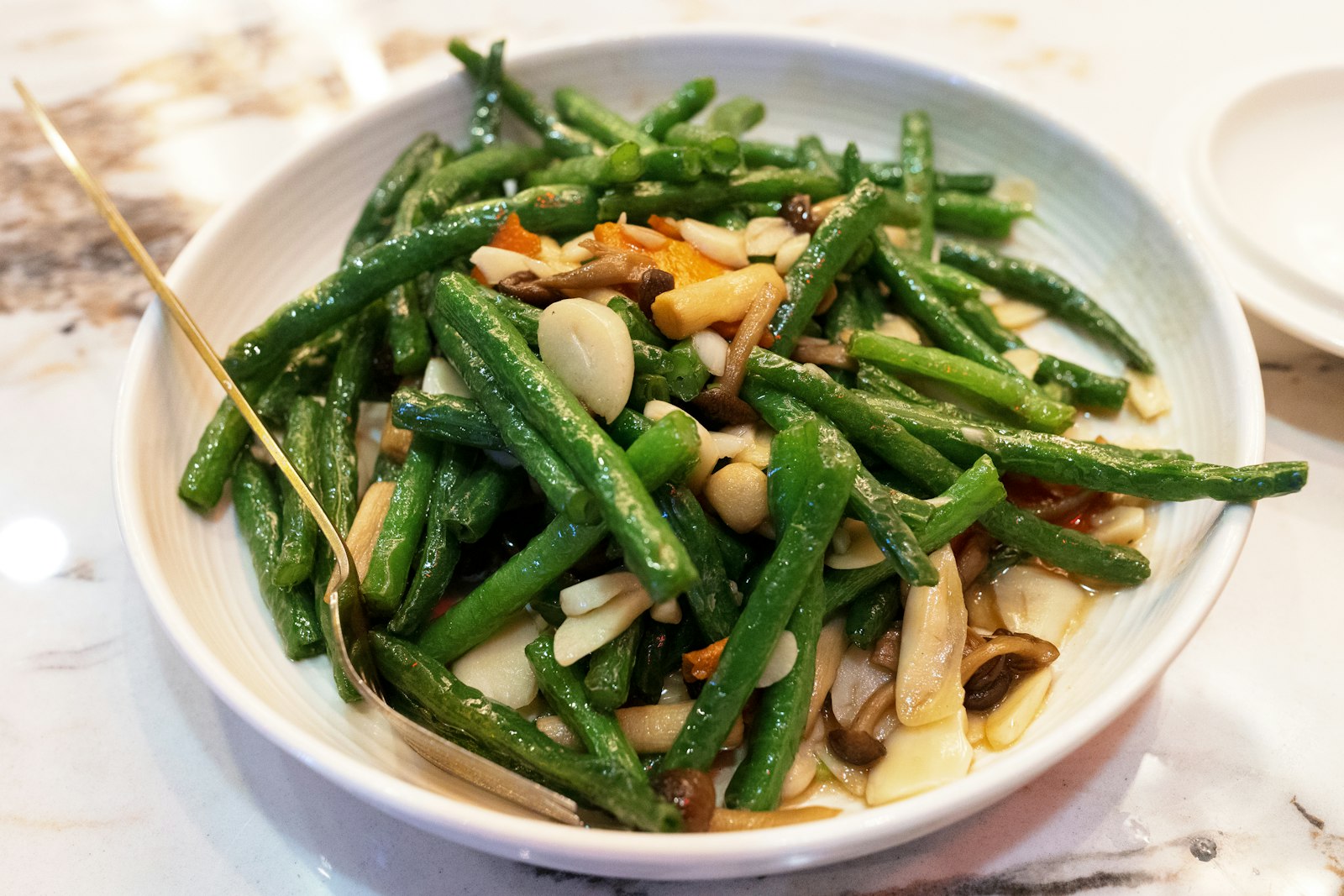 Green beans with mushrooms in a white bowl