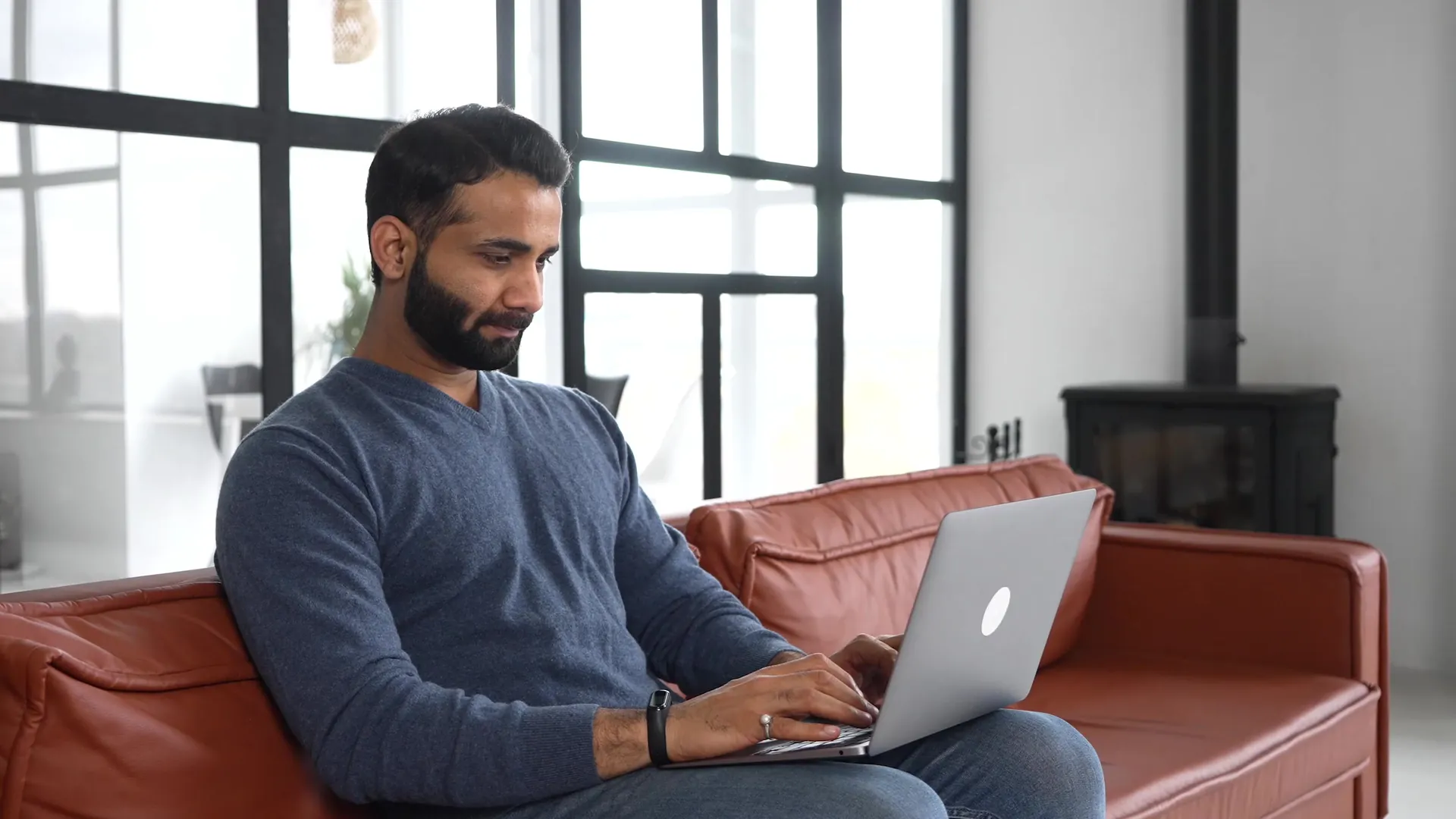 Man browsing on his laptop on the sofa