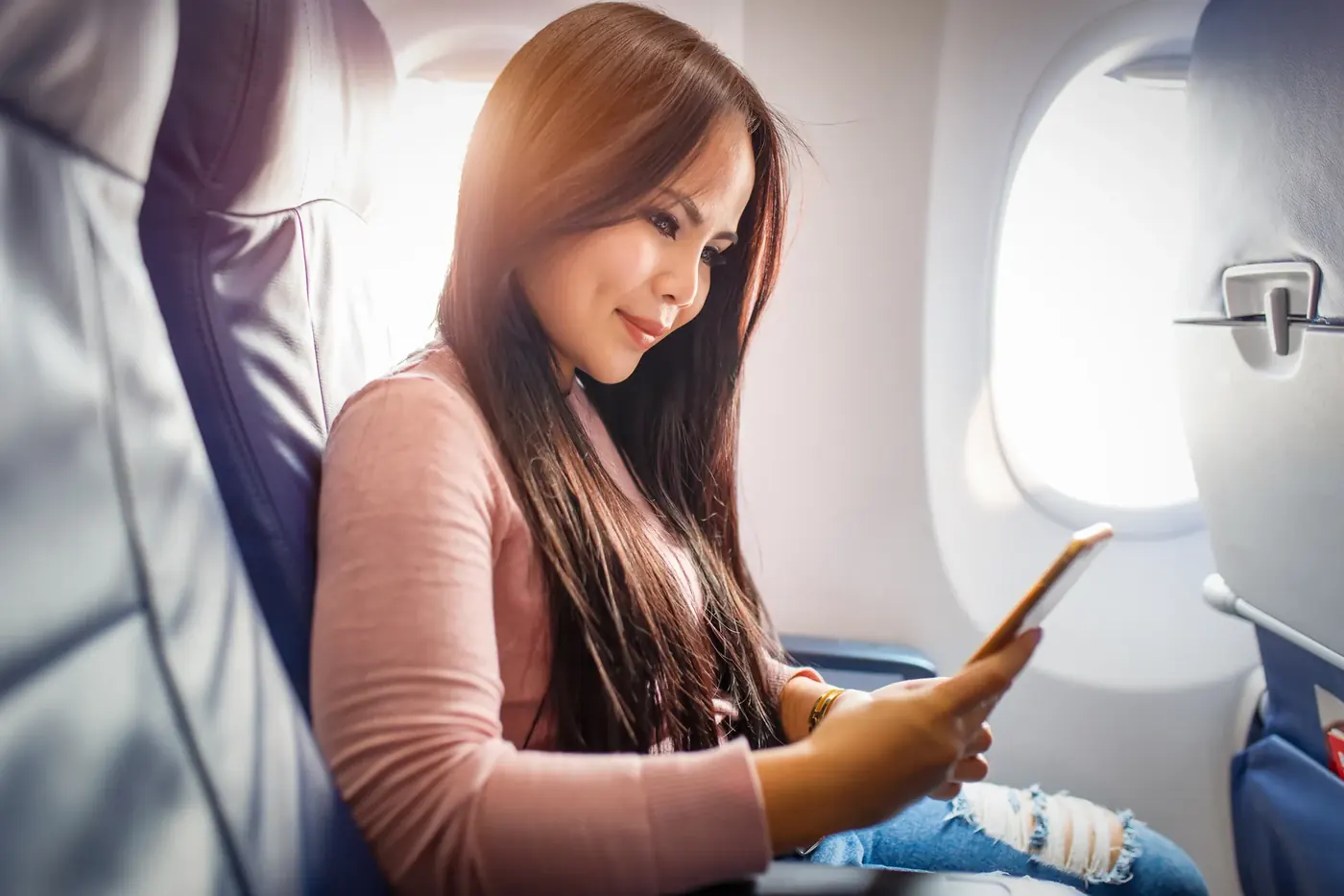Woman using her phone on a plane