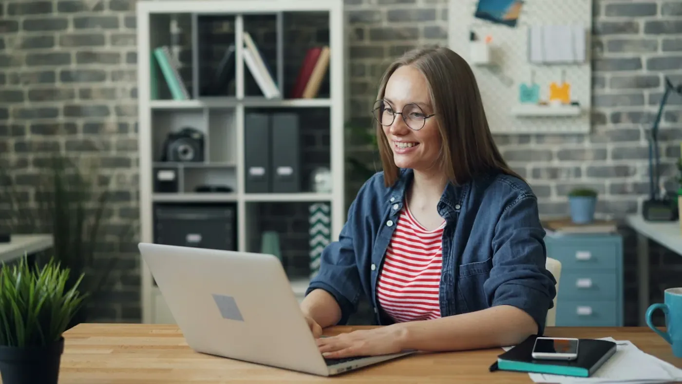 Smiling woman talking to her team on a laptop, getting ad compliance answers from Voxly Vision in Microsoft Teams