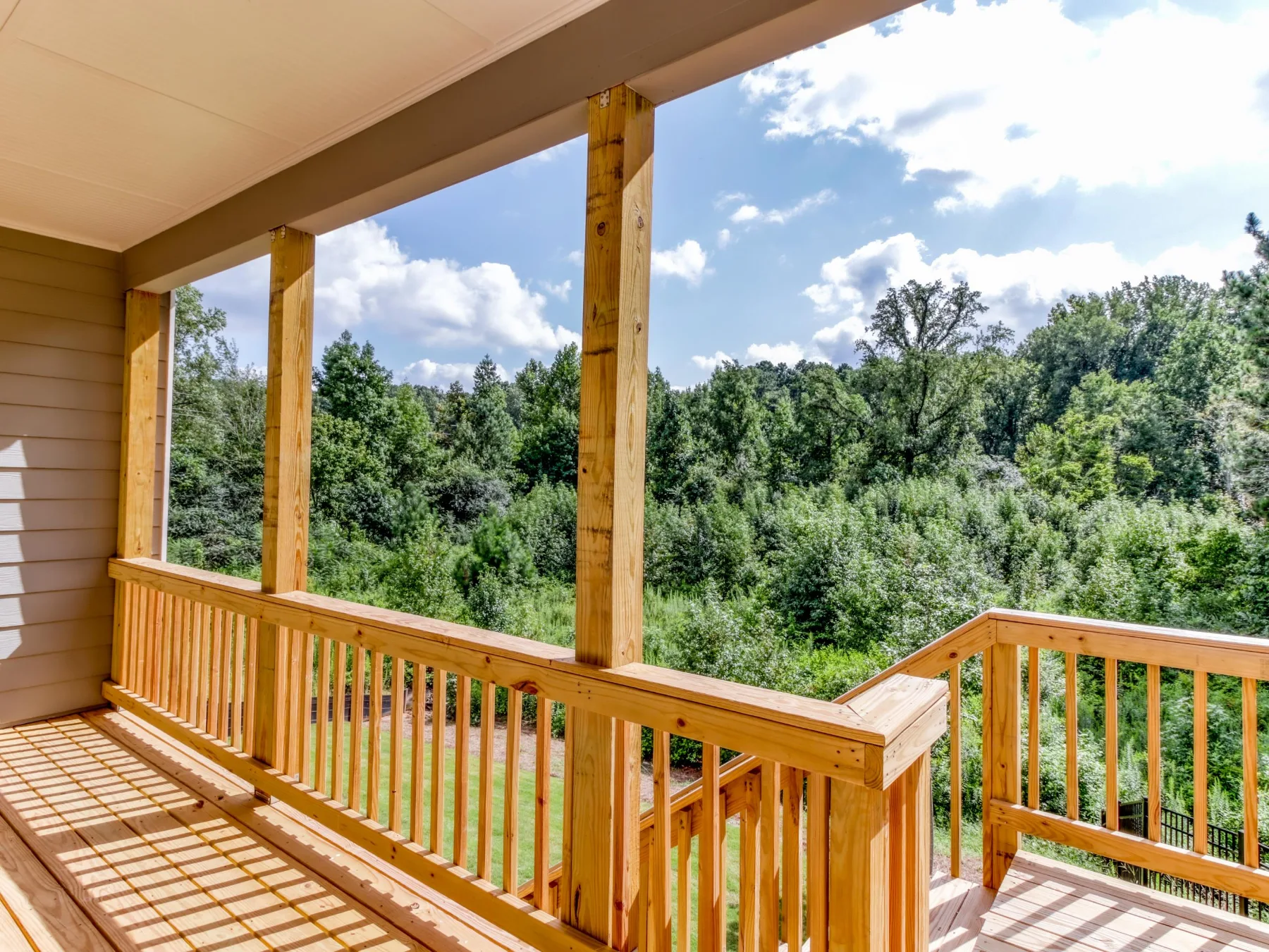 Covered back porch overlooking a wooded backyard