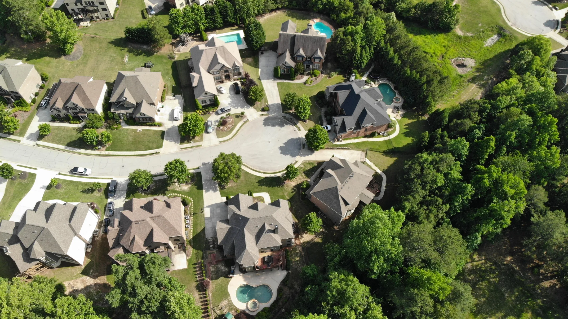 Aerial view of a North Georgia neighborhood with homes, pools, and mature trees