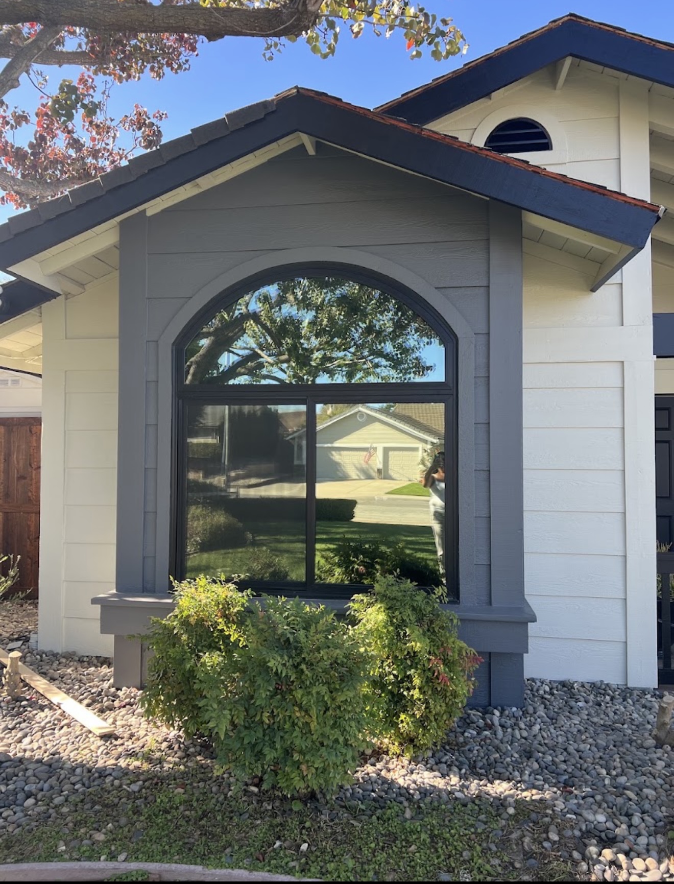 Exterior painting detail showing clean gray and white trim around a large window