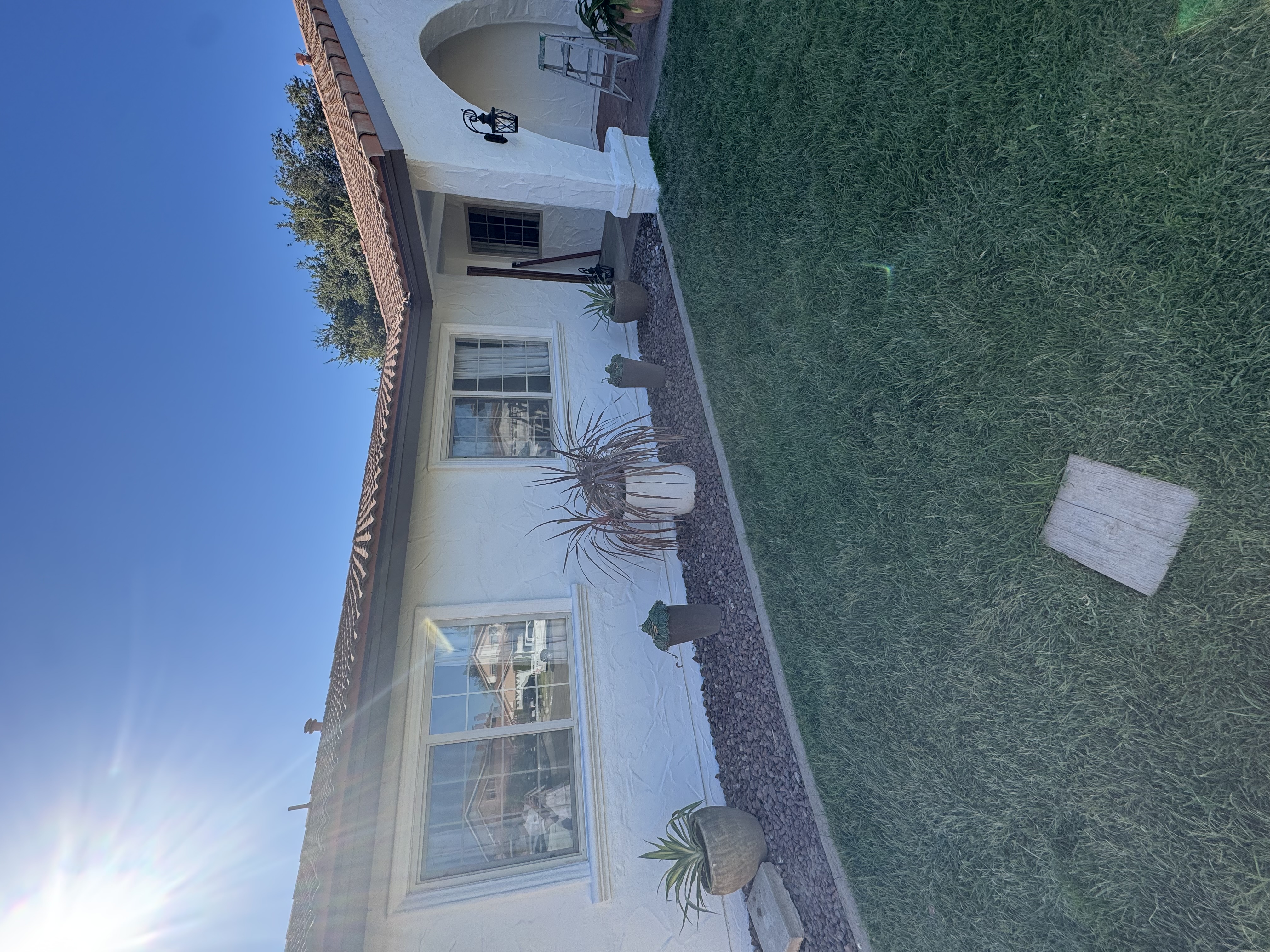 Fresh exterior finish around a home, patio, arched entry and garden