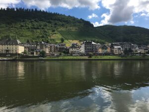 Mosel River with steep vineyard slopes and a village in Germany