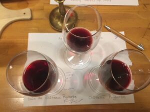 Three Bordeaux wines being compared side by side at a tasting
