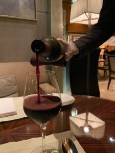 Red wine being poured during a meal while Sean and Angela were living abroad