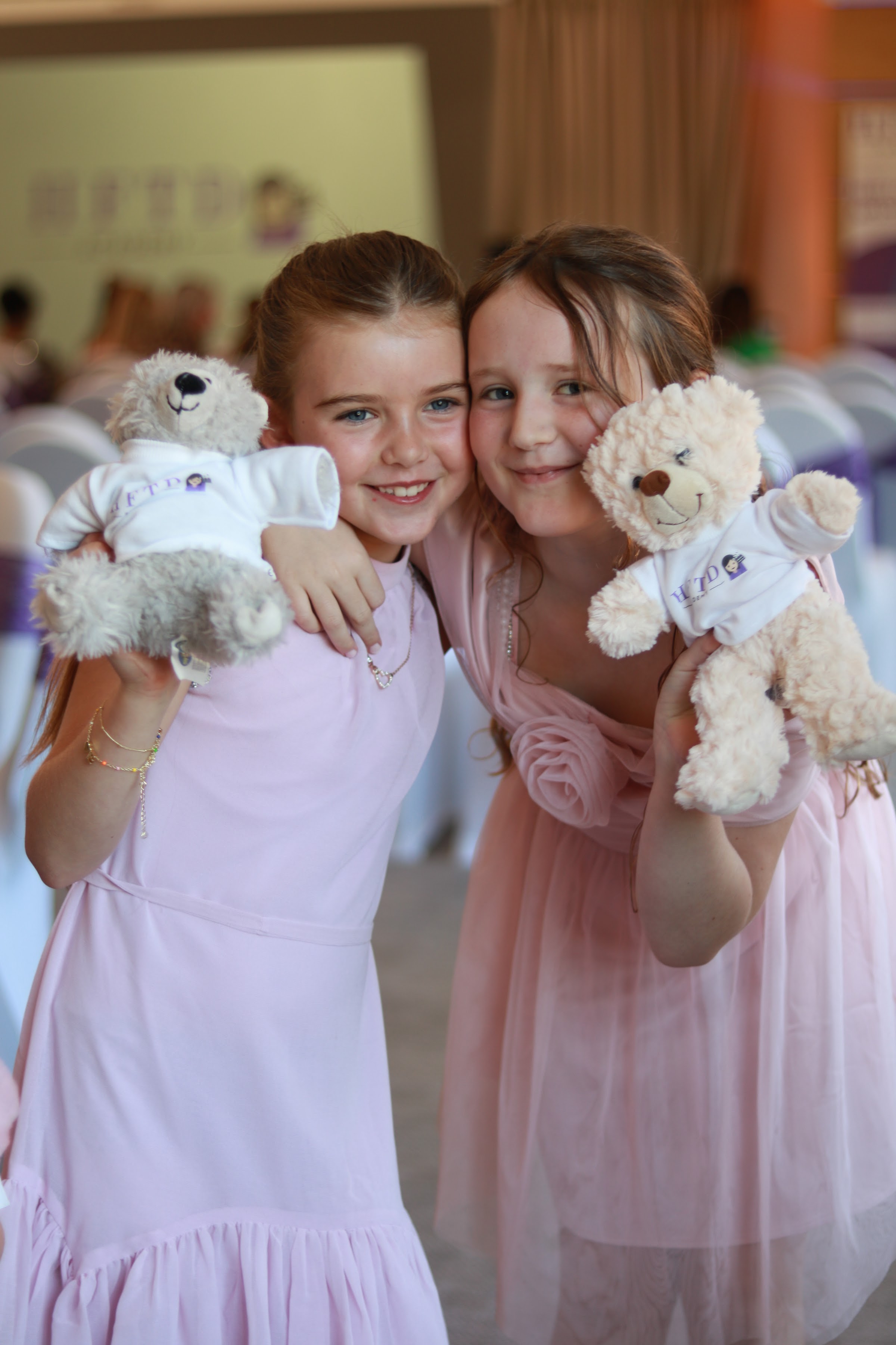 Two HFTD Juniors hugging their HFTD teddies at the HFTD Oscars