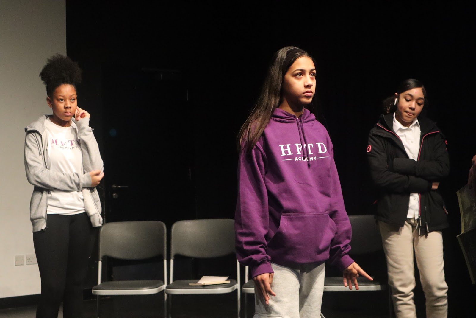 HFTD student in a purple Academy hoodie performing a scene on stage