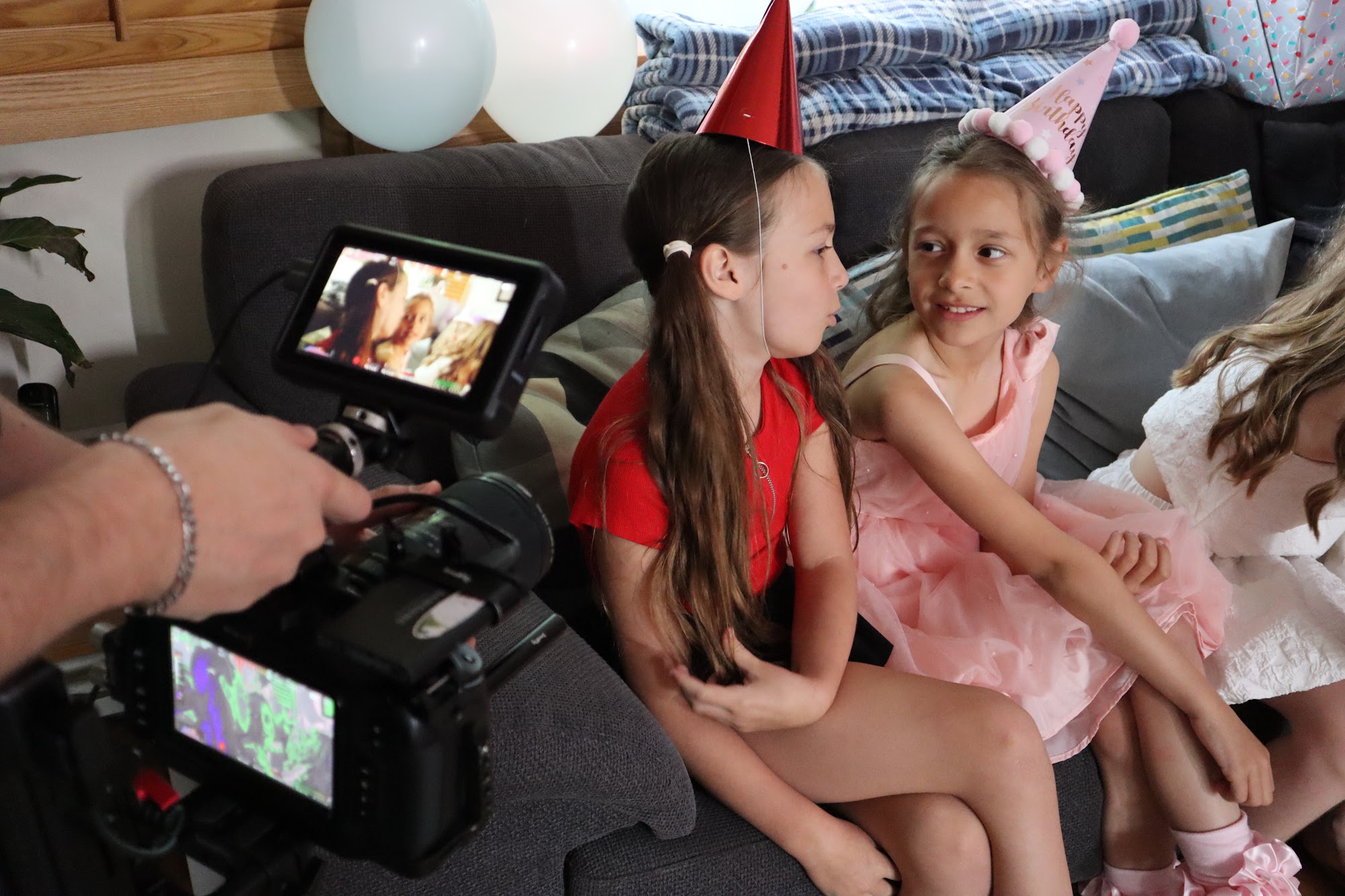 Two HFTD Juniors in party hats filming a scene with the camera in shot