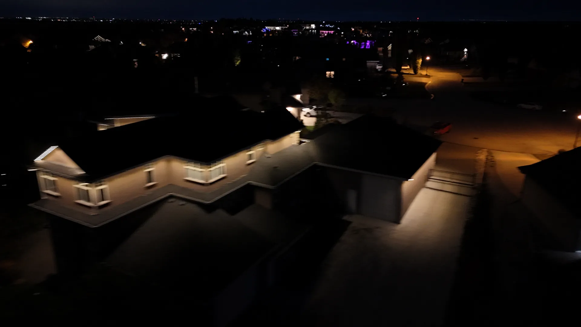Home lit with permanent LED roofline lighting at night