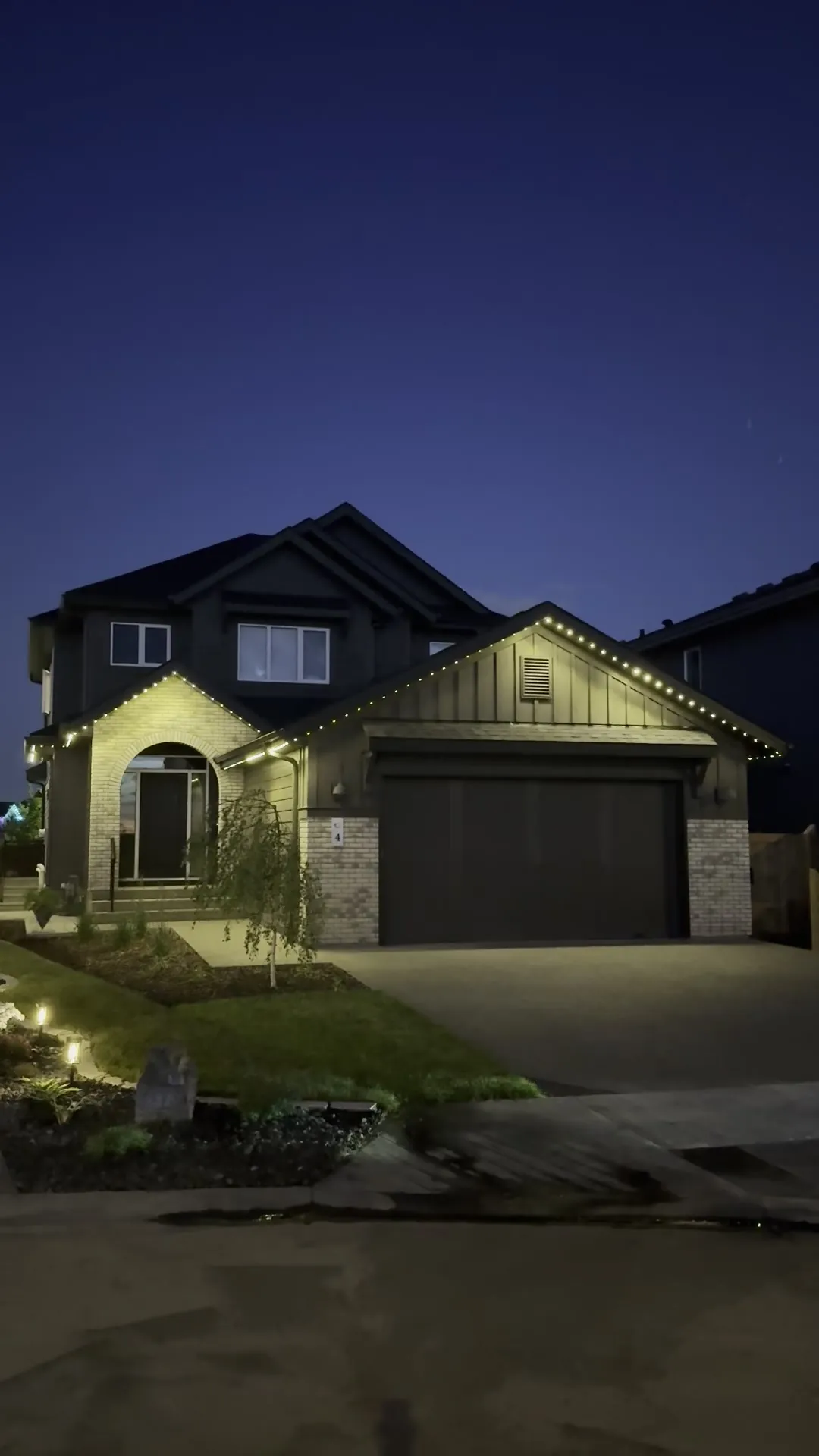 Home lit with permanent LED roofline lighting at night