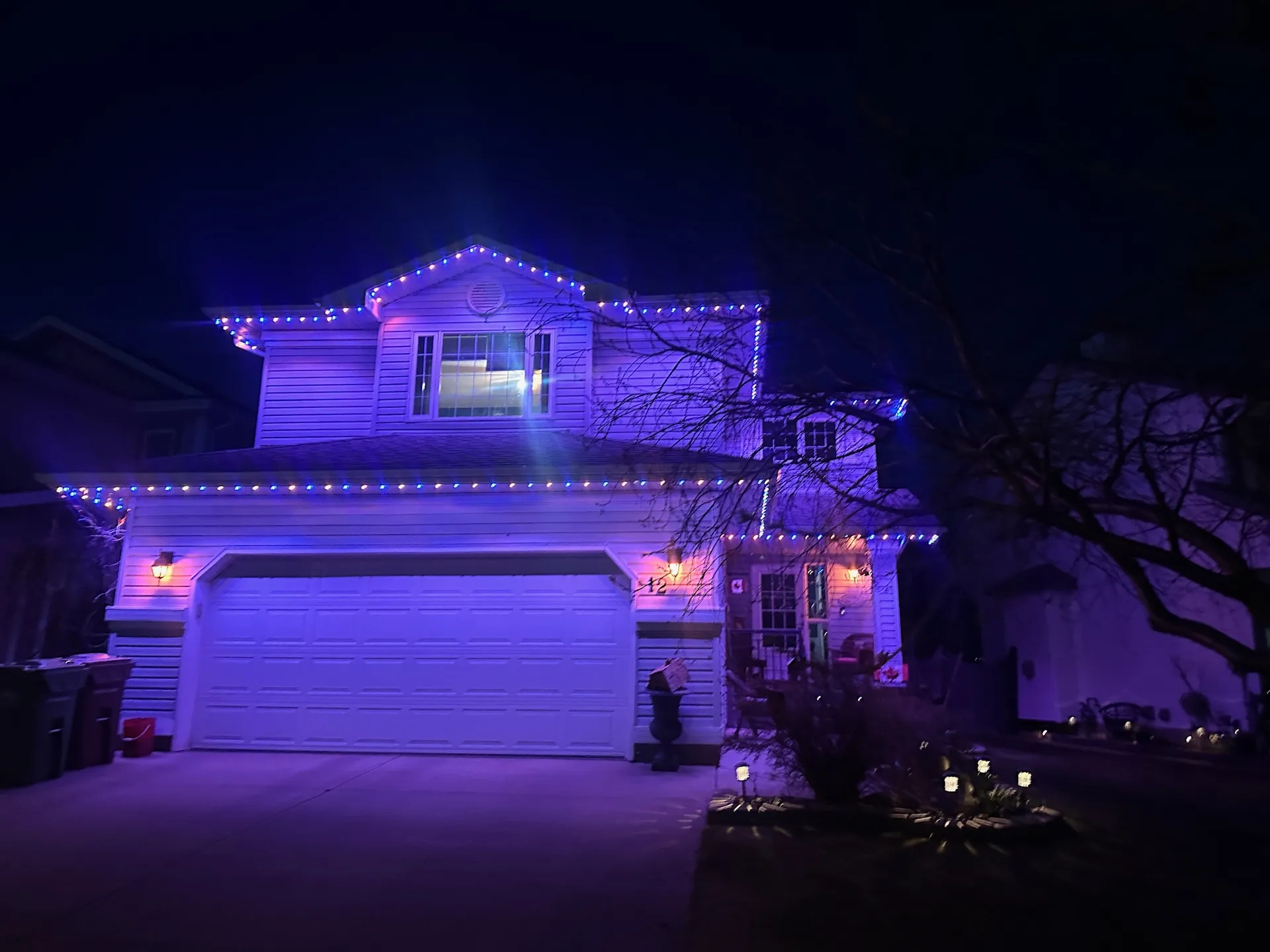 Home lit in purple and blue permanent LED lighting at night