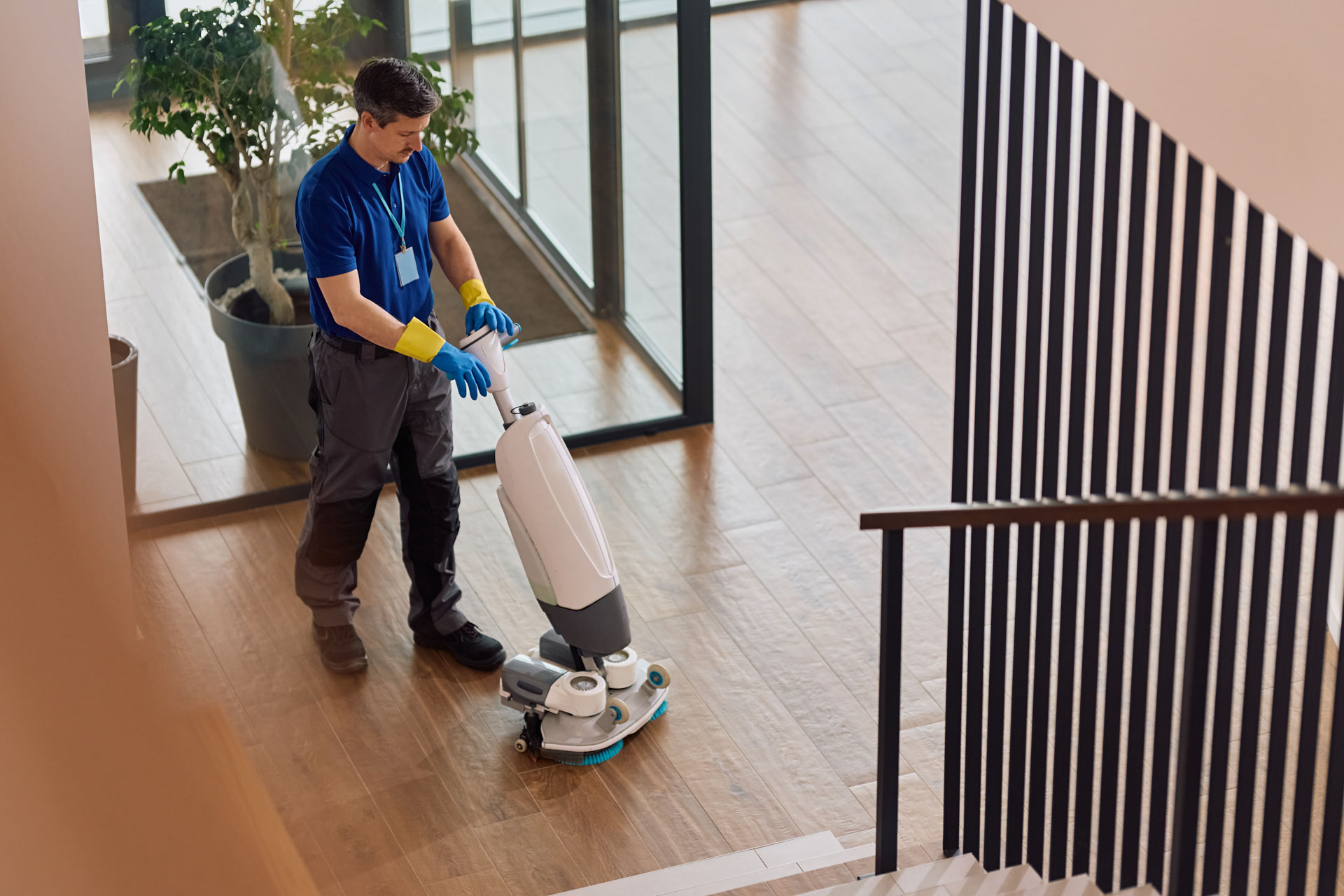 Cleaner using a floor scrubber in a commercial building foyer