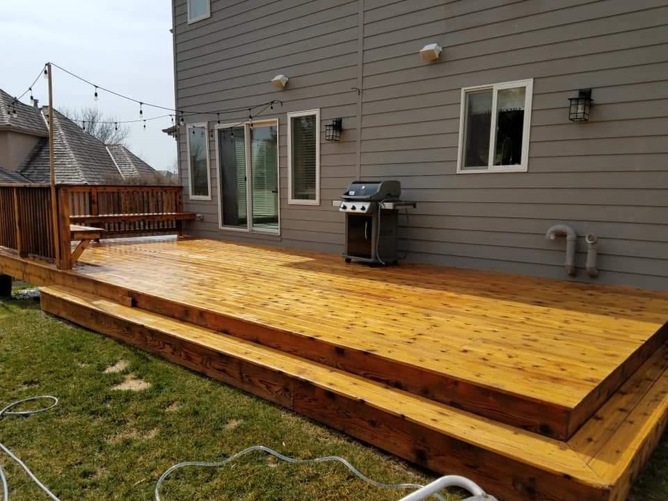 Freshly cleaned and restored outdoor deck beside a home.