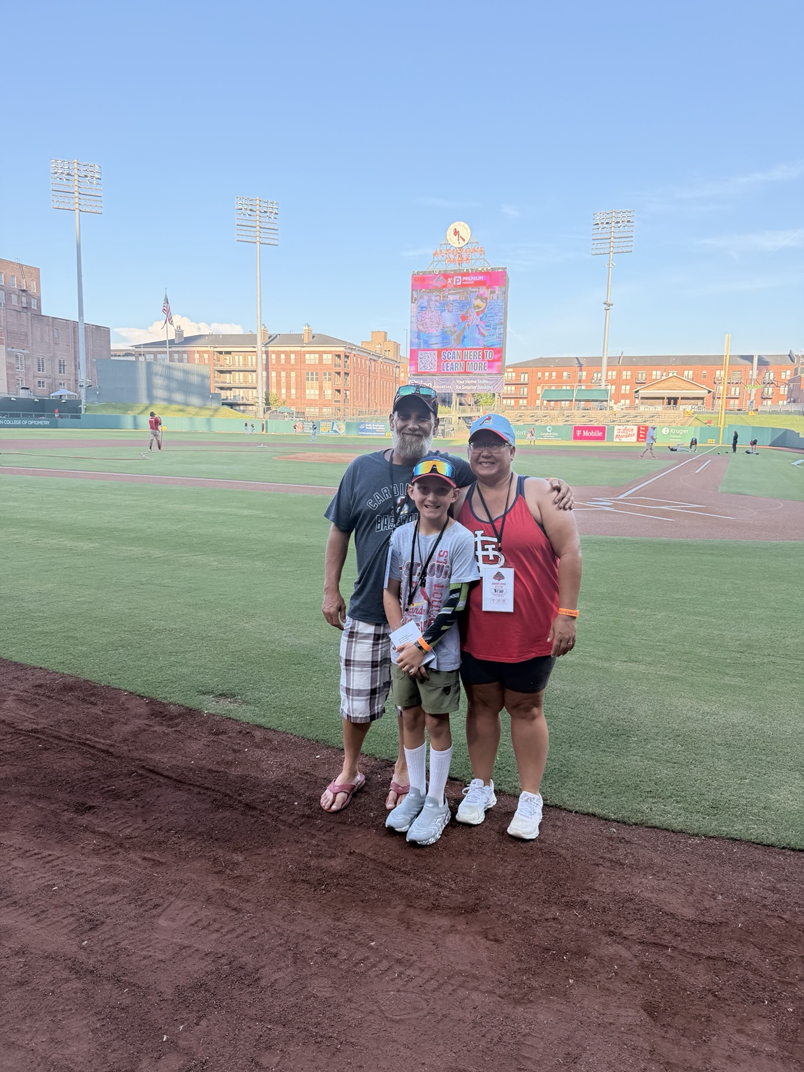 Louis Coatney, his wife, and their son Remington together at a baseball field.