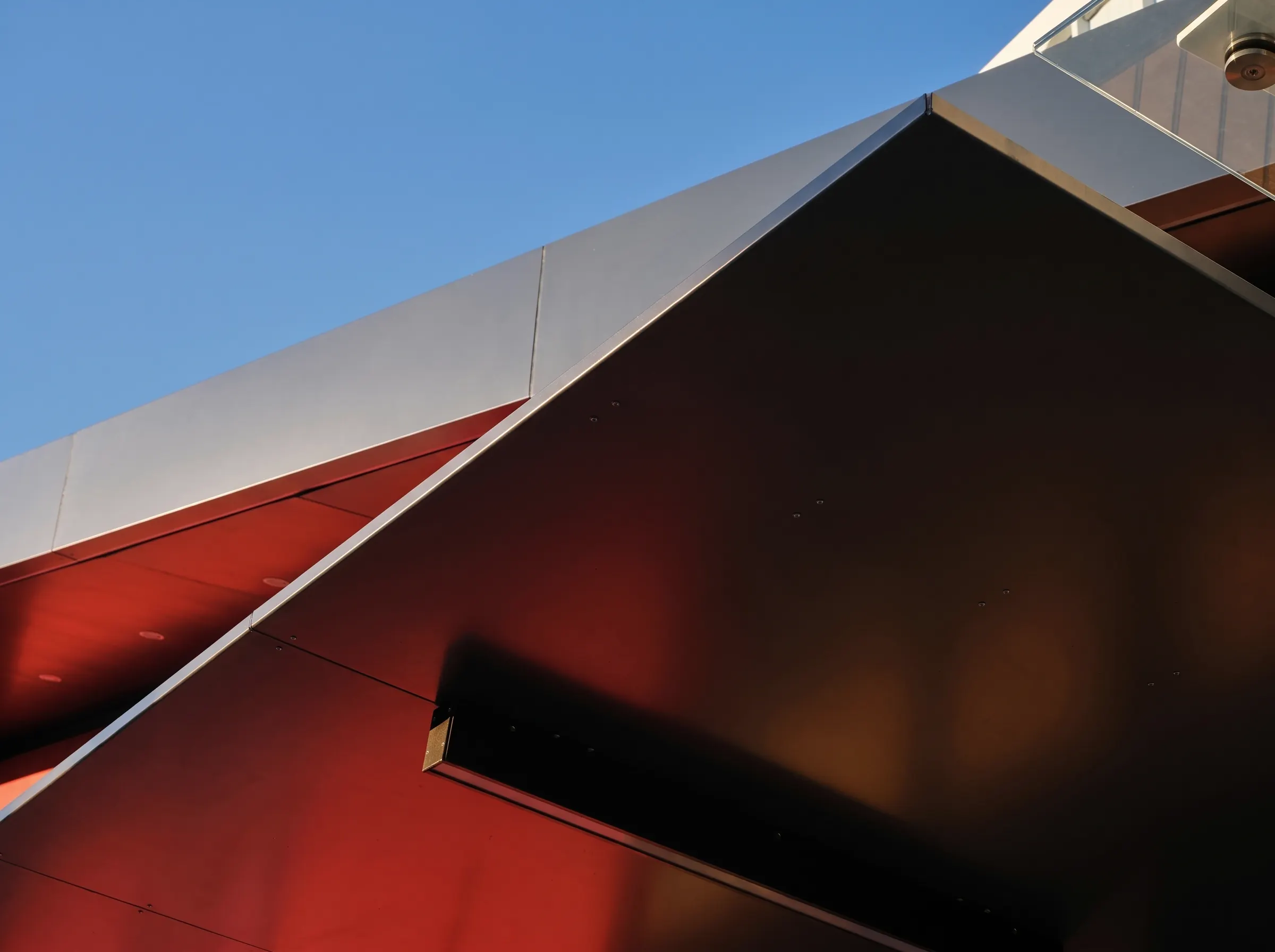 The black canopy at 6 Carr Road from below, with the red wall reflected in its underside