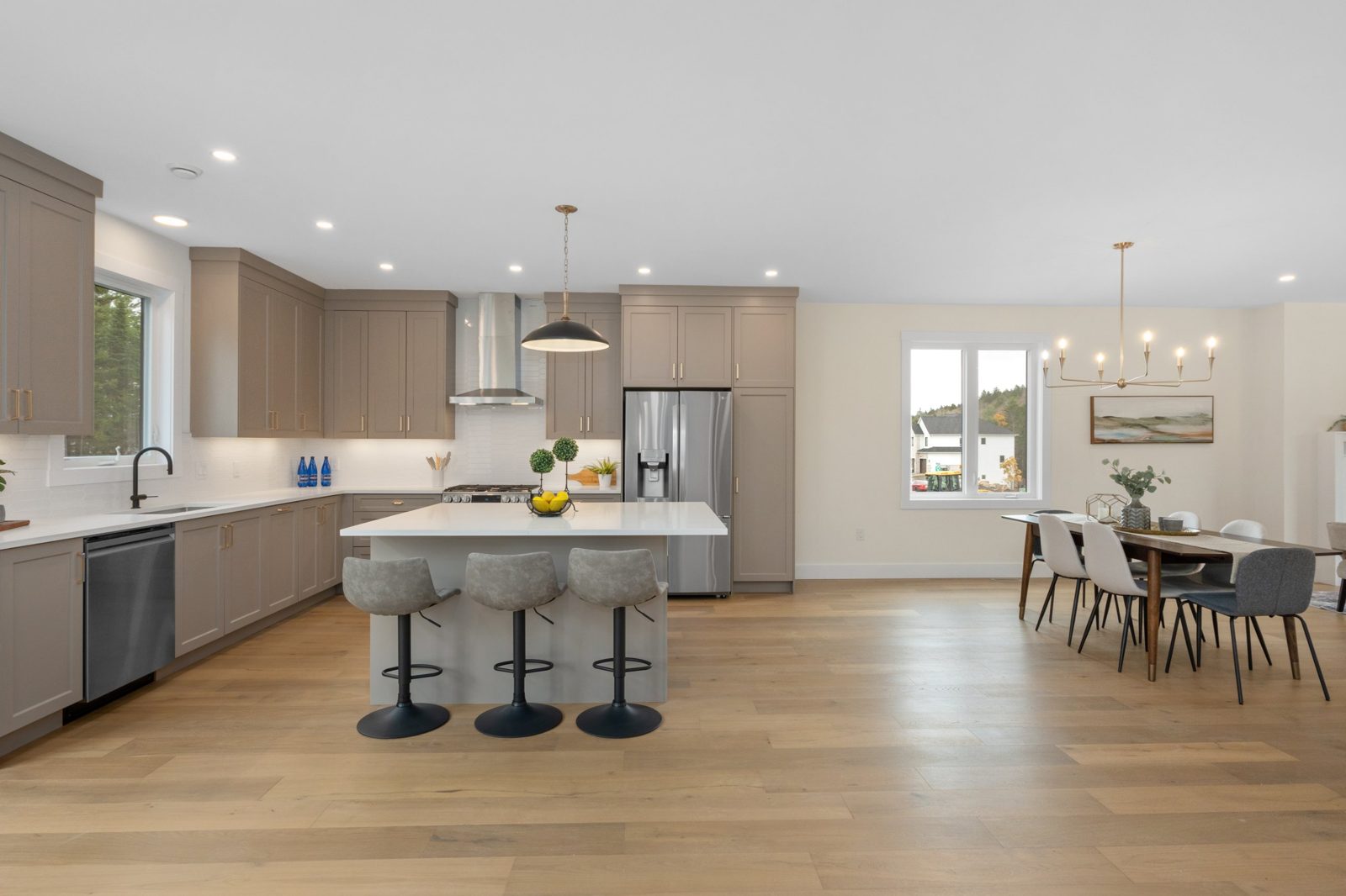 Open kitchen with island and taupe cabinetry in a Shaughnessy Homes new build