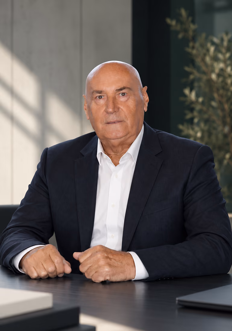 Portrait of Nazim Honic, Chairman and CEO of HONEX Group, seated in a modern office.