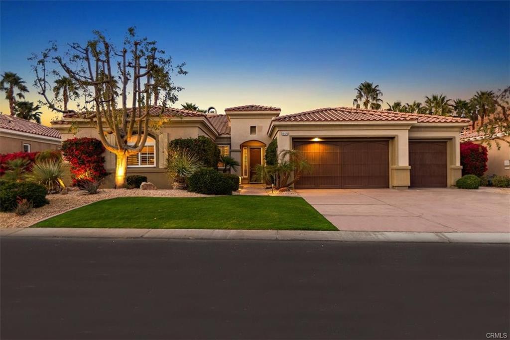 Single-story Spanish-style home with a tile roof at dusk