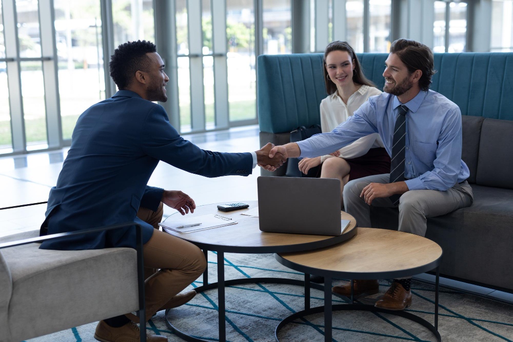 A salesperson greeting a client with a handshake