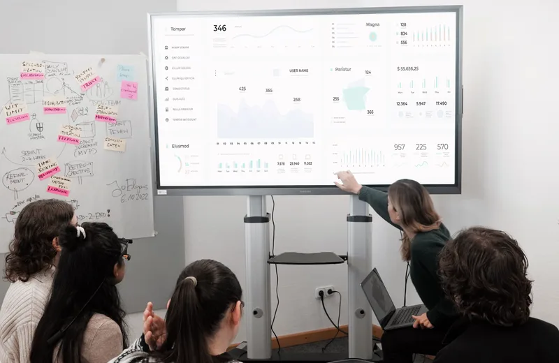 Team bespricht ein Betriebs-Dashboard am Bildschirm