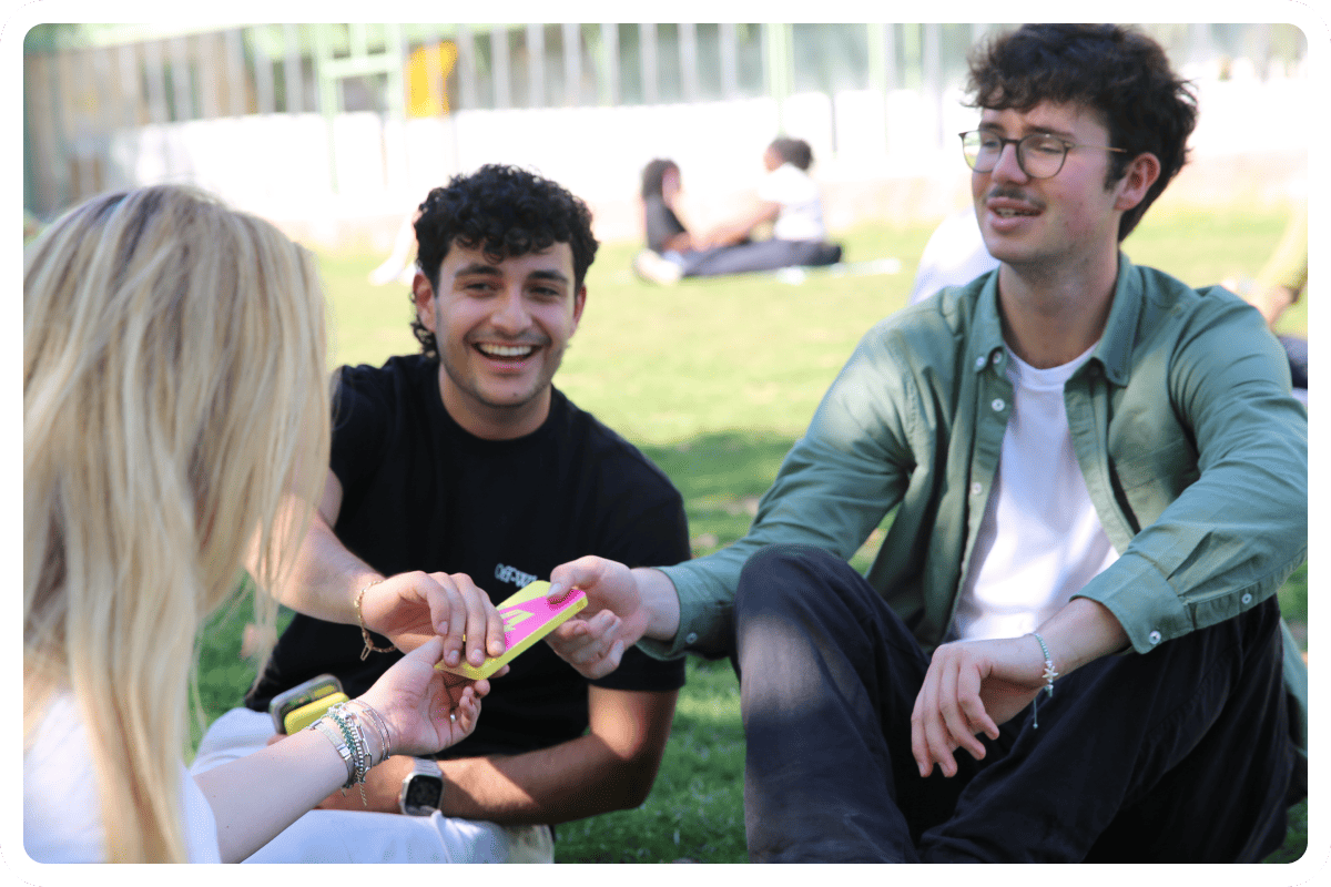 Young people sitting on the grass holding a OneFlash power bank