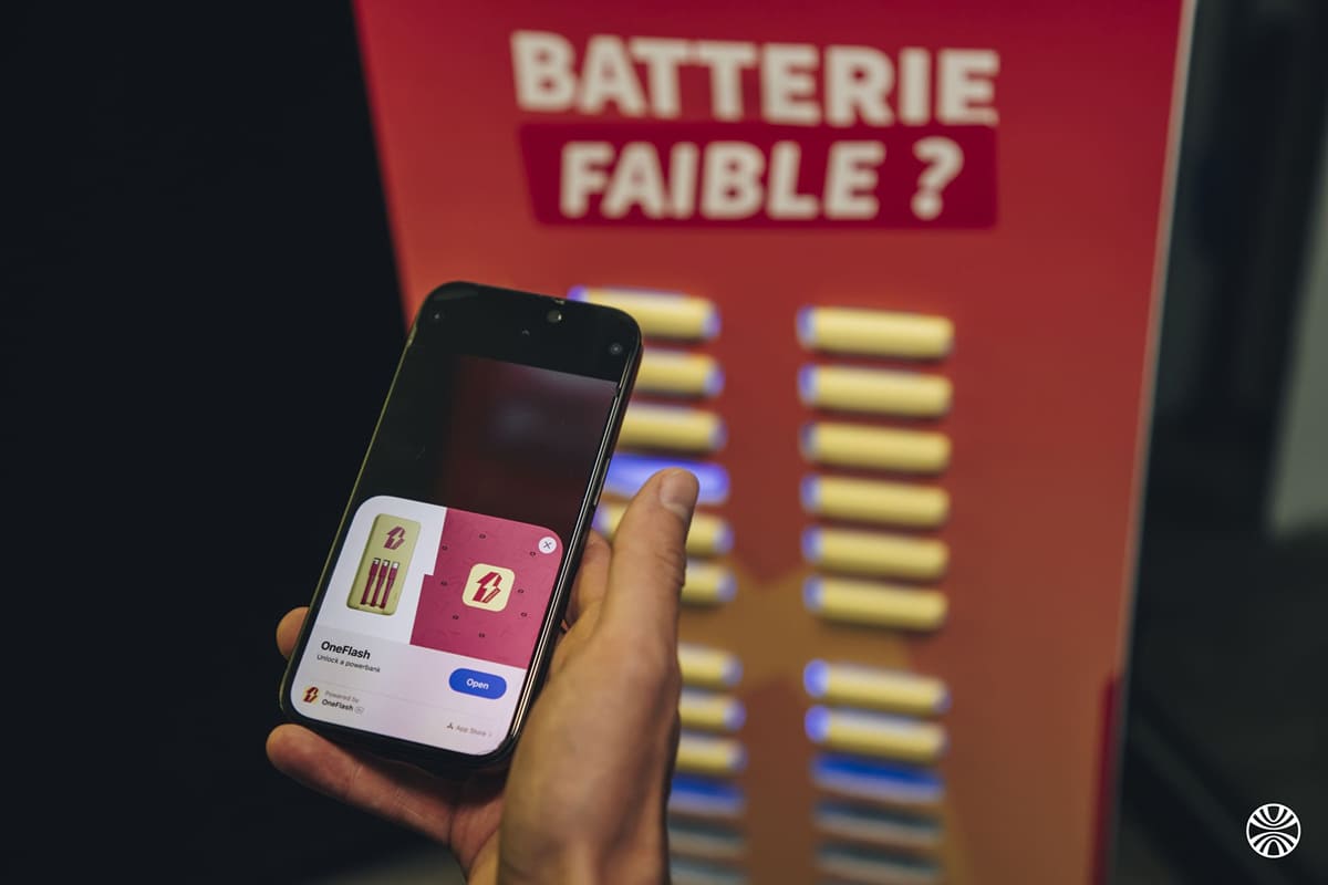 Phone showing the OneFlash app in front of a station