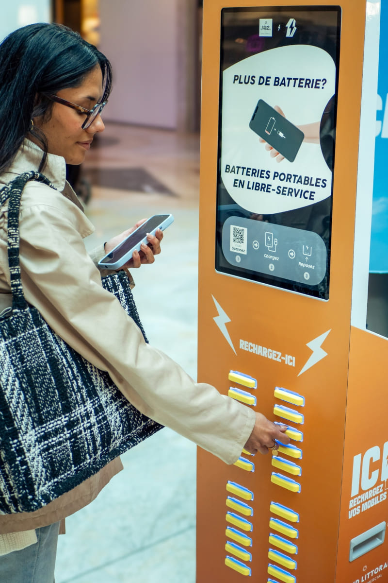 User taking a power bank out of a OneFlash charging station