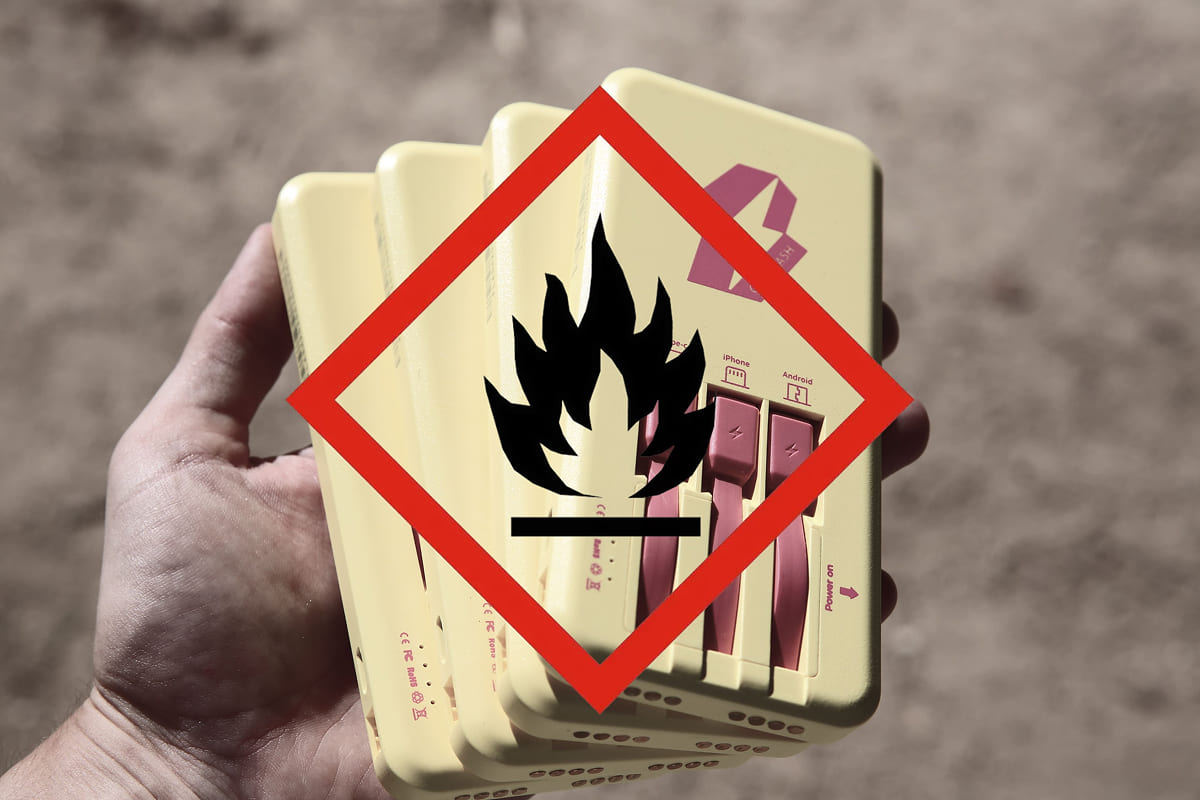 Hand holding power banks with a danger symbol
