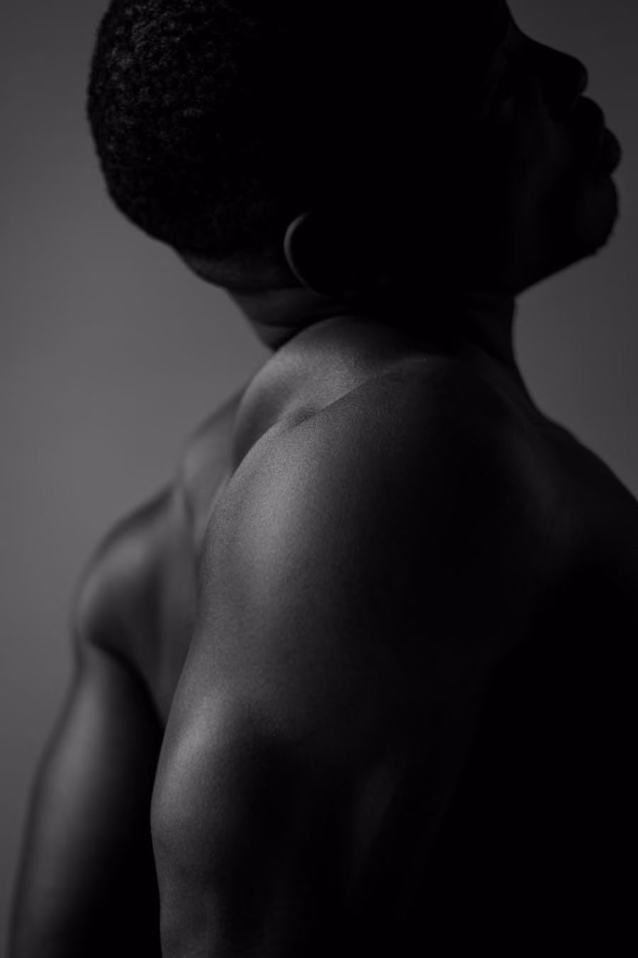 A member's shoulder and back in low, soft light