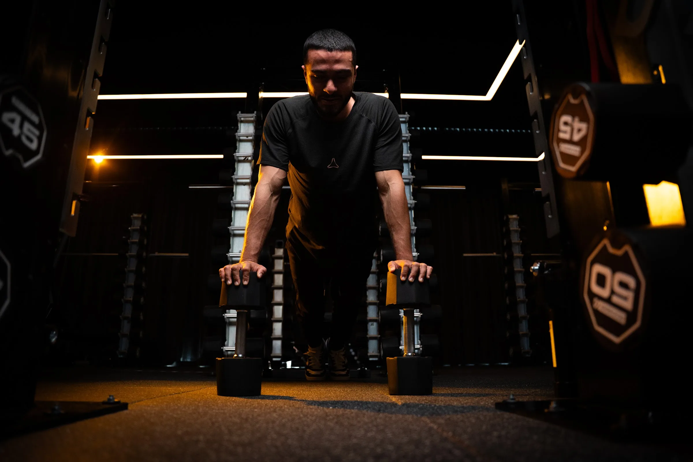 A member holding a push-up on floor handles in the LF3 Hybrid studio