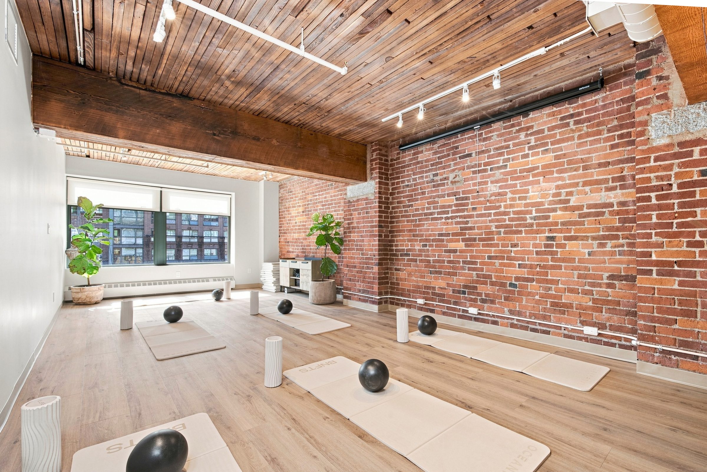 A corner of the BNFTS floor — exposed brick, timber beams and a tall window onto Hamilton Street