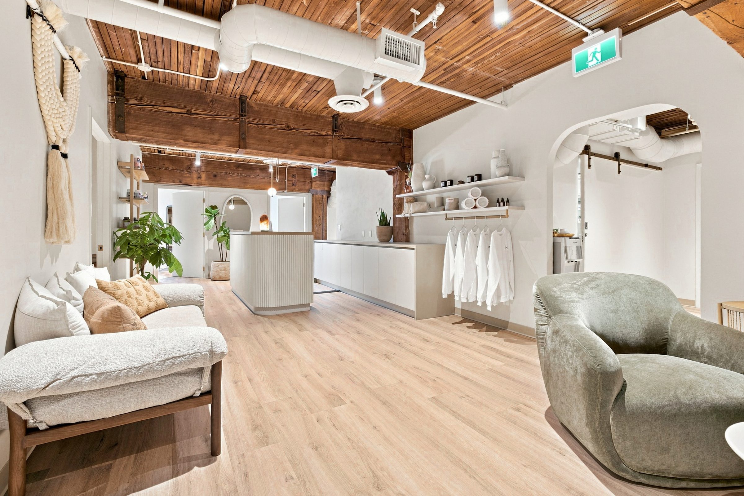The front of the clinic — open shelving, plants and a sofa on a wide wood floor