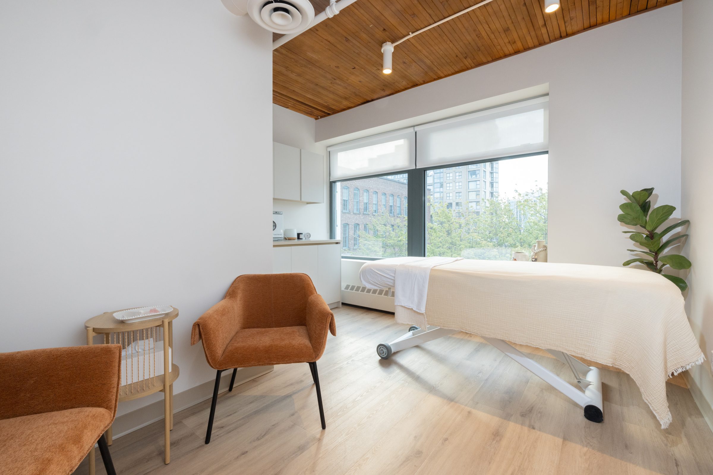A treatment room at BNFTS with a made-up table, a chair and windows along one wall