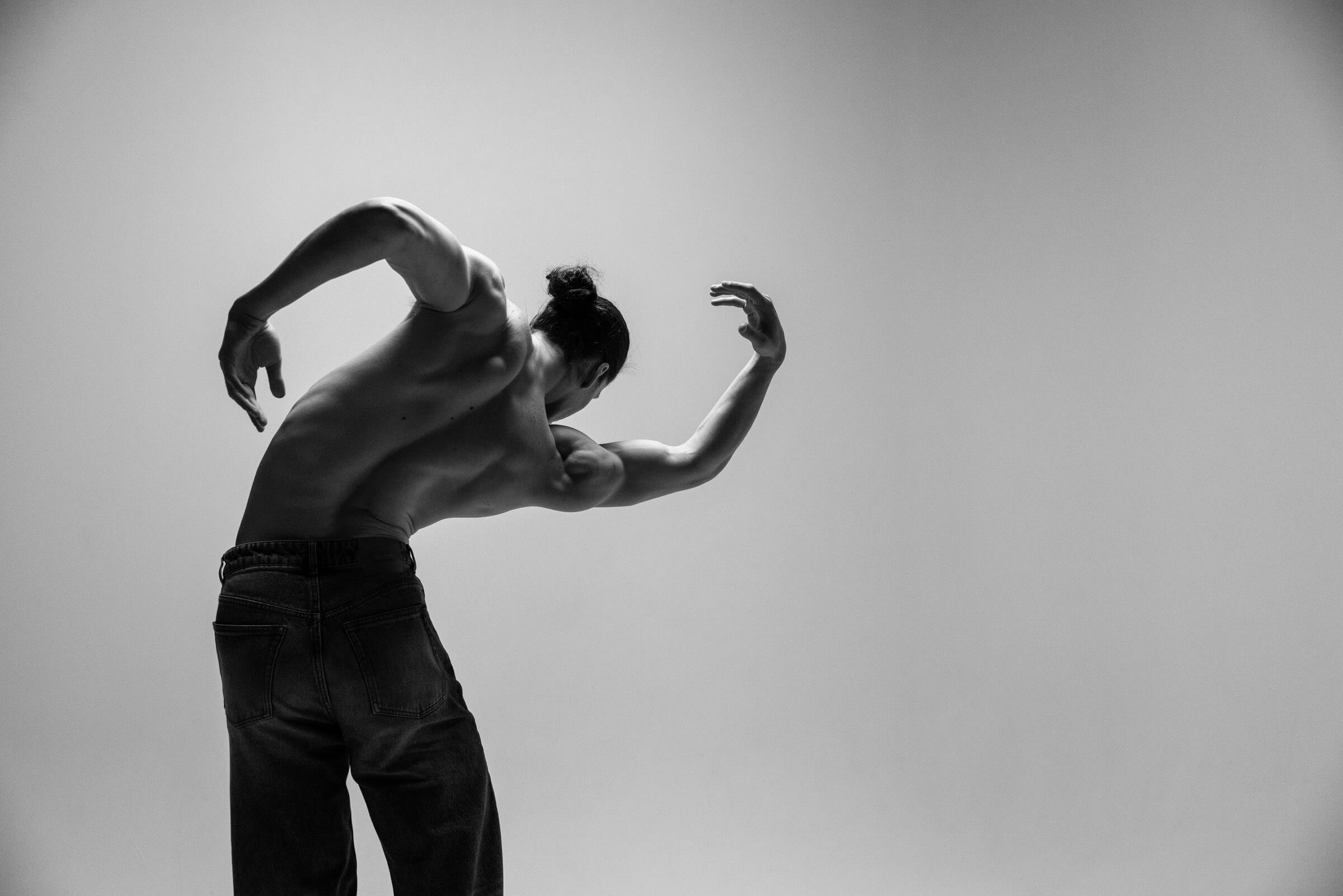 A dancer folded forward with arms raised, from the BNFTS studio shoot