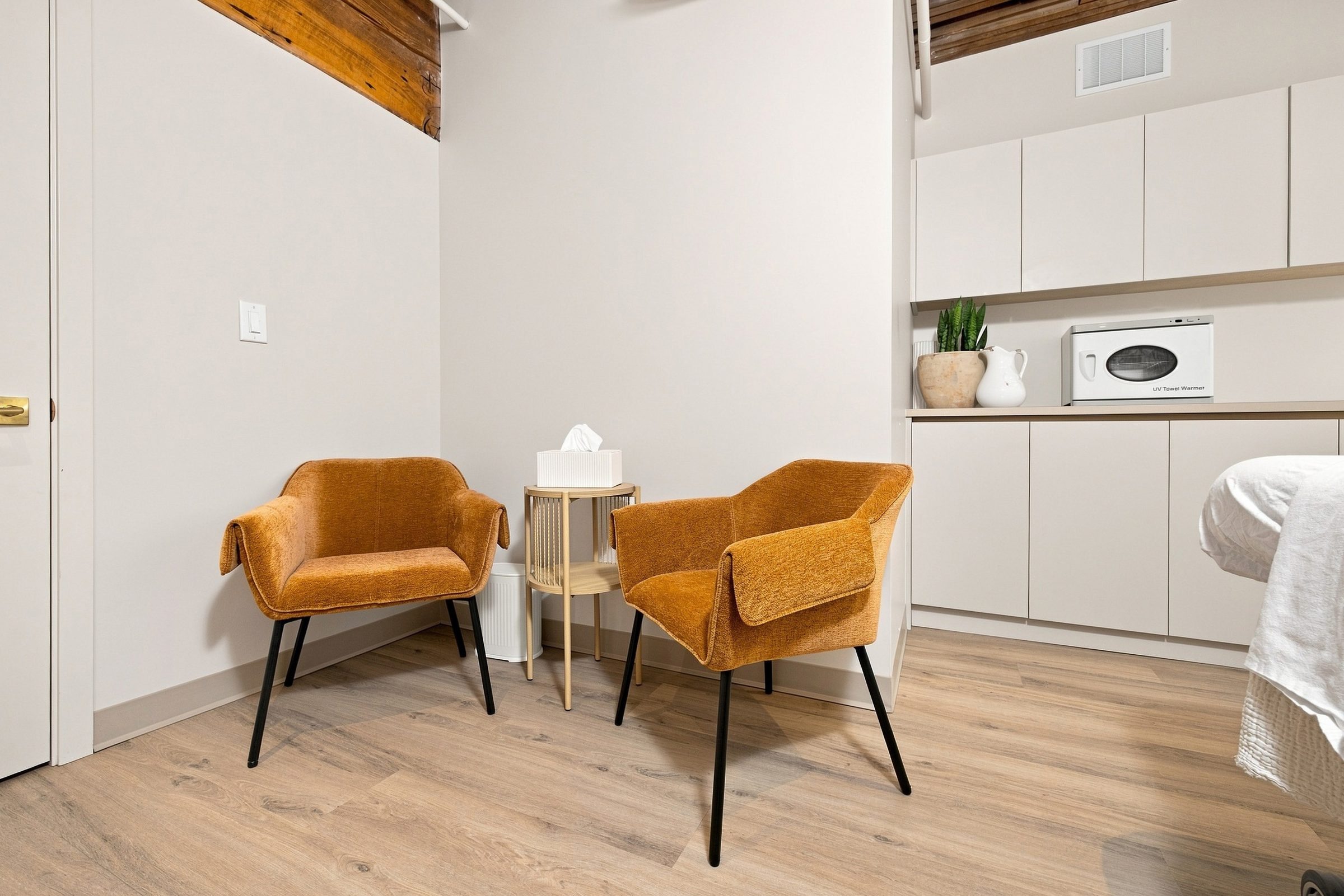 A consultation room at BNFTS with two chairs and a treatment table