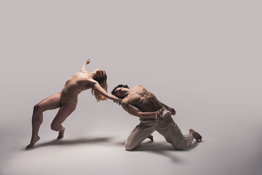 Two dancers reaching toward one another, one nude and lunging forward, one kneeling in loose trousers, from the BNFTS Unbound campaign