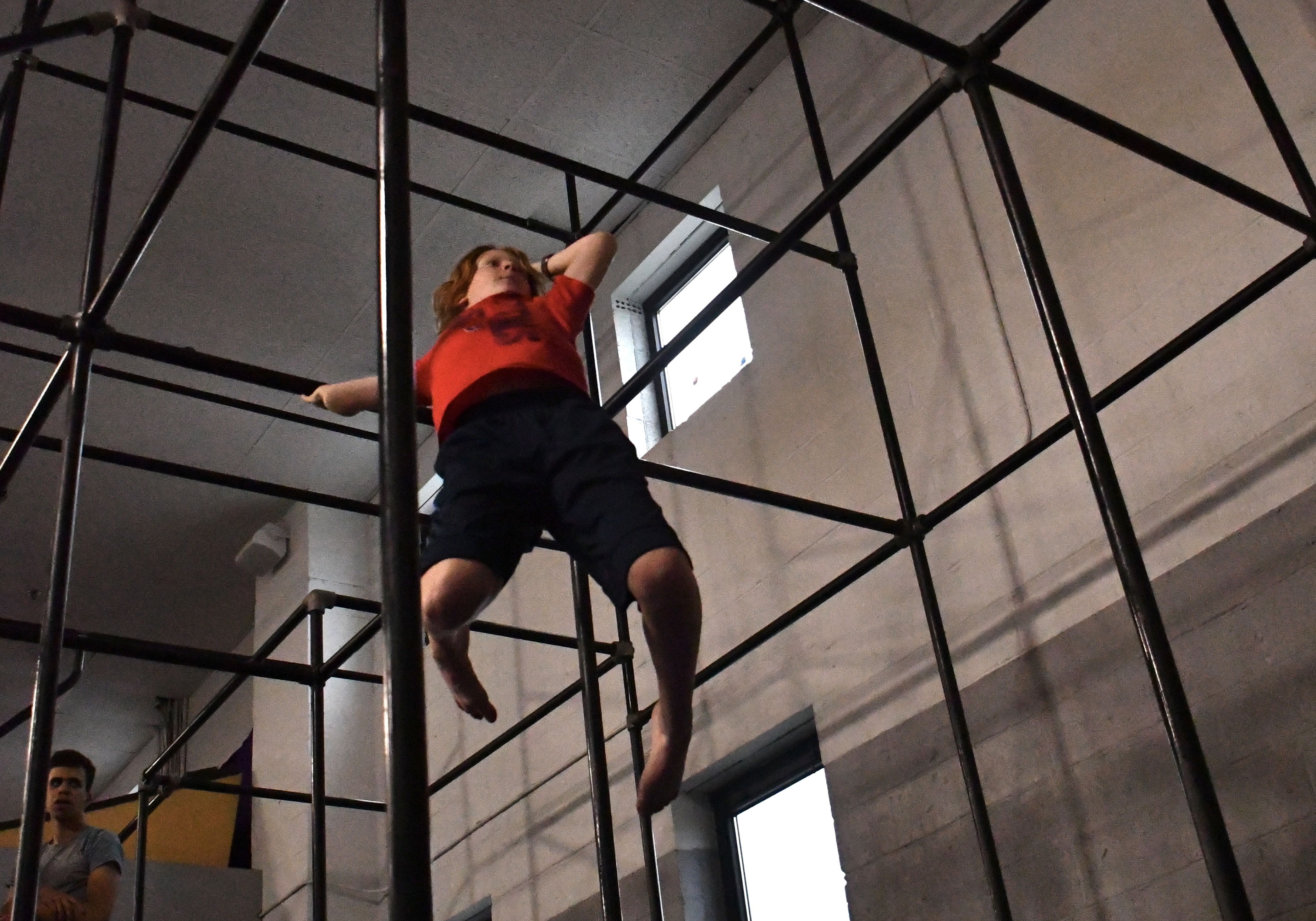 Athlete climbing the steel rig at Bolt Parkour