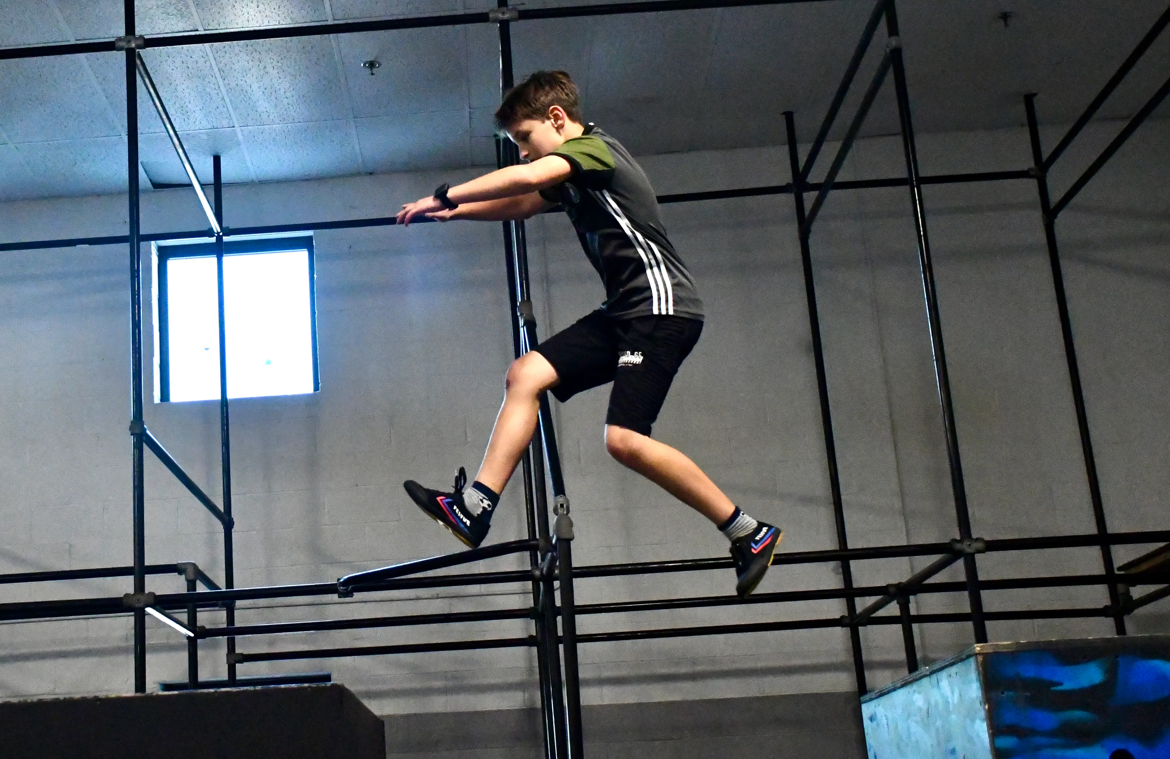 Boy leaping between obstacles at Bolt Parkour