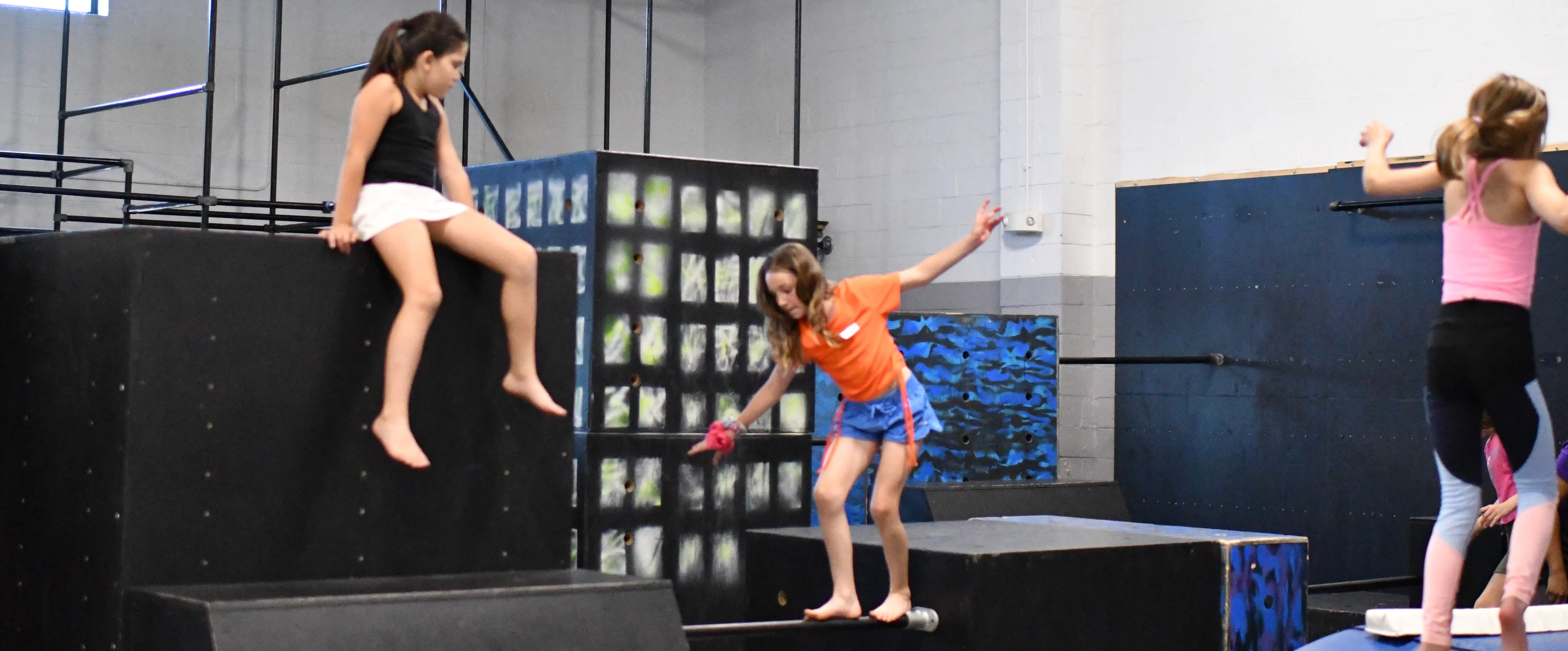 Campers climbing on parkour boxes at a Bolt Parkour camp