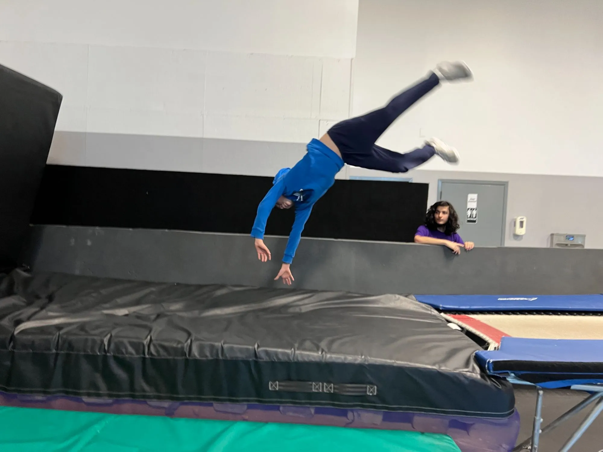 Athlete flipping an aerial cartwheel over the crash pit at Bolt Parkour in North Bethesda, MD